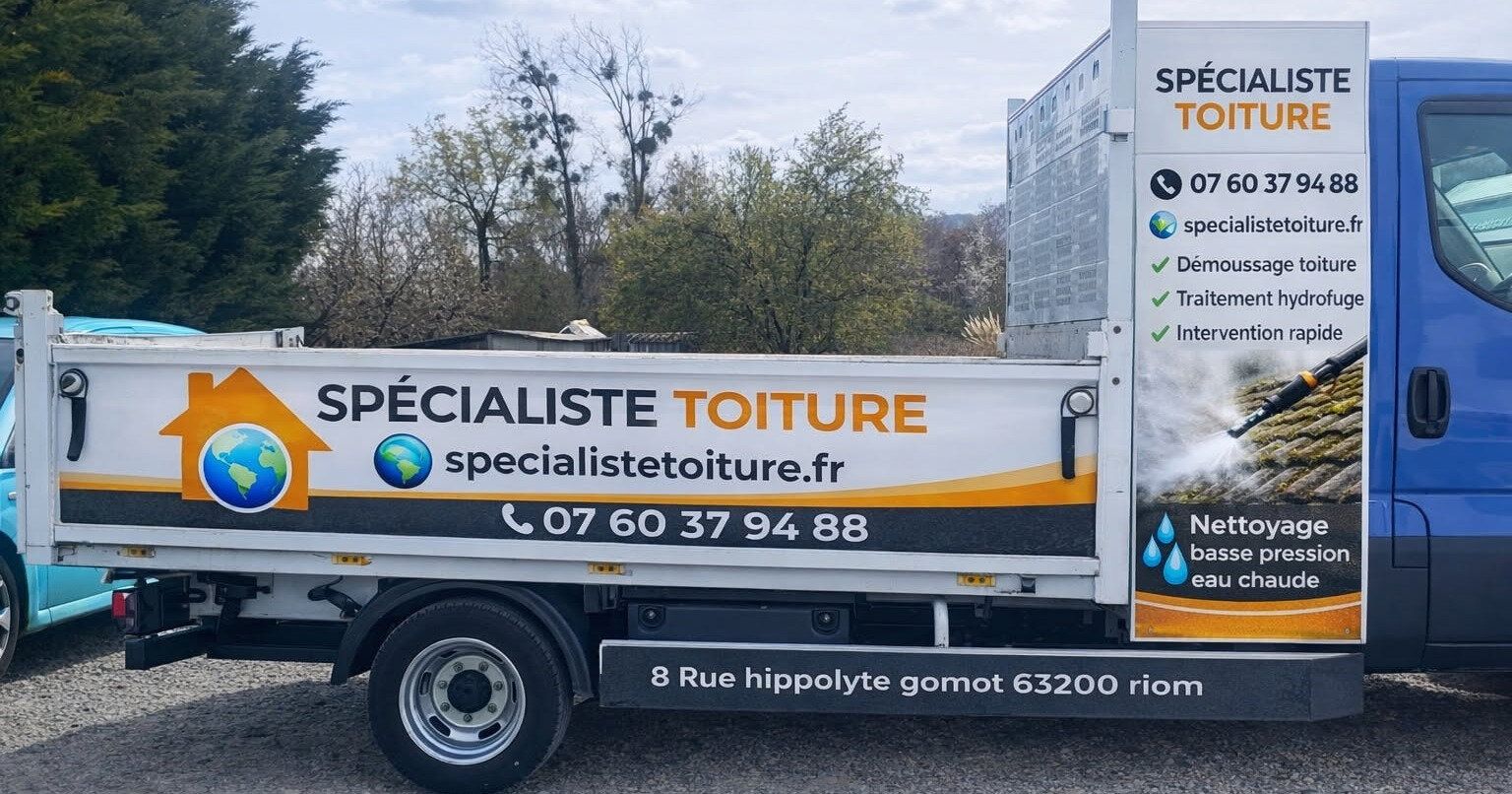 Camion floqué Spécialiste Toiture, garé sur un chantier à Riom